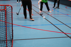 En grupp människor som spelar innebandy