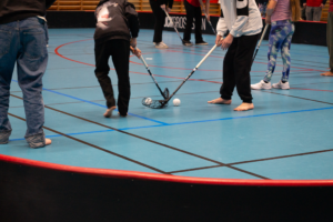 En grupp människor som spelar innebandy