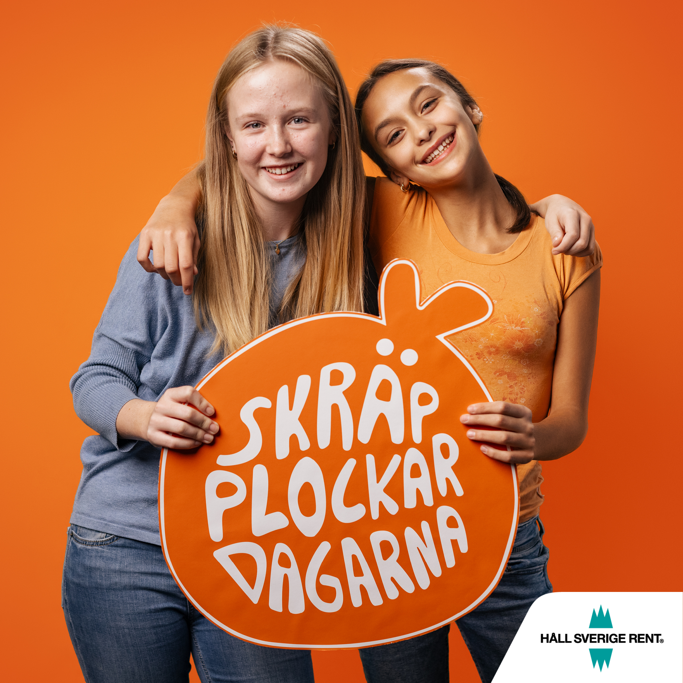 Två unga tjejer som håller i en orange sylt där det står skräpplockardagarna